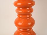 an orange vase that is sitting on a table