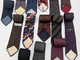 many ties laid out on a white surface