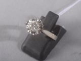 an image of a diamond ring sitting on top of a piece of wood