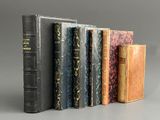 plusieurs vieux livres sont alignés sur une surface grise