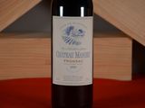 a bottle of wine sitting on a table next to a wooden box