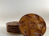 four brown plates sitting on top of each other on a table