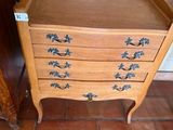 une petite commode en bois dans un coin de la pièce