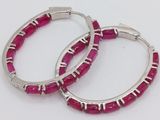 pair of silver hoop earrings with pink stones on white background