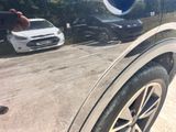 a reflection of a person taking a picture of a car