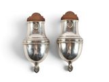 deux vases en argent posés sur une surface blanche