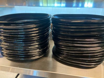 de nombreuses assiettes noires empilées les unes sur les autres sur une étagère