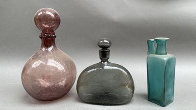 trois bouteilles en verre posées les unes à côté des autres sur une table