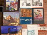 plusieurs livres posés sur une table, sur laquelle se trouve un ordinateur portable