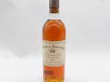 une vieille bouteille de whisky posée sur une table blanche