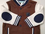 the jacket is brown and white with a blue stripe on the sleeves