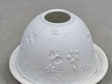 a white bowl with a flower design on it on a plate