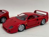 two red toy cars sitting next to each other on a white surface