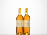 two bottles of wine sitting on top of a table next to each other