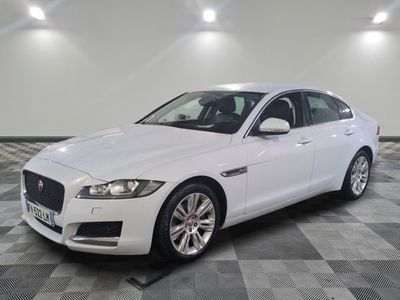the white jaguar is parked in a large room with checkered flooring