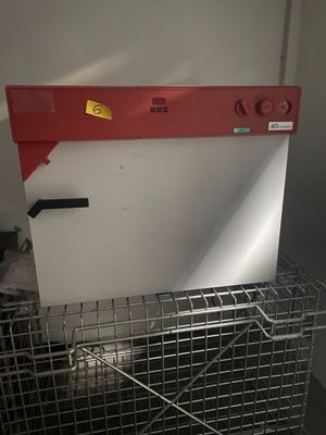 une cage métallique avec un toit rouge et une porte blanche