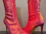 des bottes à talons hauts rouges et roses posées sur une surface réfléchissante