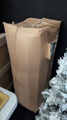 a cardboard bag sitting on top of a table next to a christmas tree