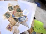 une pile de timbres posée sur une feuille de papier, elle-même posée sur une table