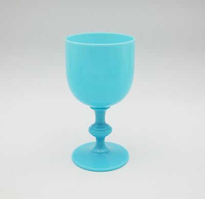 a blue glass cup sitting on top of a white table