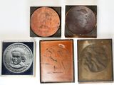 quatre types différents de plaques en bronze et en cuivre sur un fond blanc