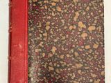 un vieux livre à la couverture rouge posé sur une table