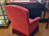a pink chair sitting in front of a window in a room