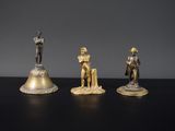 trois figurines de chevaliers et une cloche posées sur une table