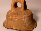 a brown bell with a dog on it sitting on a table
