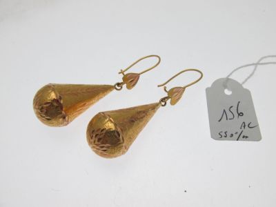 une paire de boucles d'oreilles en or sur fond blanc, avec une étiquette de prix