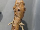 a wooden walking stick with an old man ' s face on it