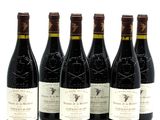six bottles of wine are lined up in a row on a white surface