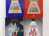 trois livres posés sur une table blanche, avec une couverture rouge, bleue et noire