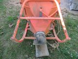 a small orange machine that is sitting in the grass
