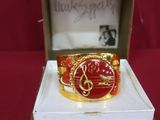 an image of a red and gold ring in a box