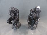 deux figurines d'un homme et d'une femme assis sur un rocher