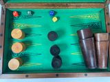 a wooden backgam board with several pieces of game on it