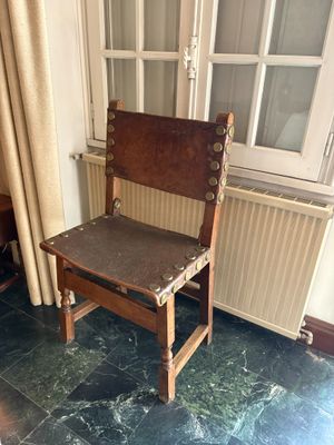 une chaise en bois posée devant une fenêtre