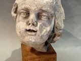 sculpture of a child ' s head on a wooden block