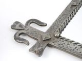 a metal sword with a cross on it on a white surface