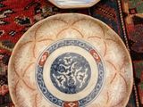 two blue and white plates sitting on top of a red rug