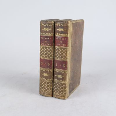 Deux vieux livres sont posés l'un sur l'autre sur une surface blanche.