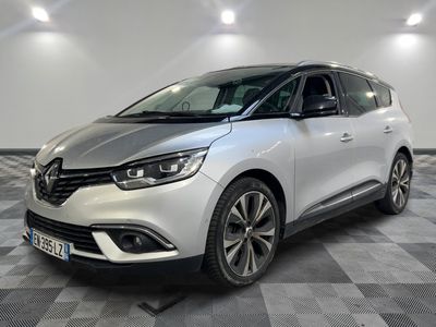 une voiture argentée garée dans une pièce au sol en damier