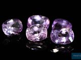 un groupe de trois pierres précieuses violettes posées sur une surface noire