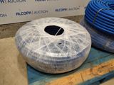 two rolls of blue hoses wrapped in plastic on a pallet