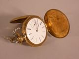 a gold pocket watch with a chain around it