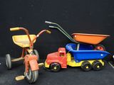 un tricycle pour enfant à côté d'un camion jouet et d'un tricycle pour enfant