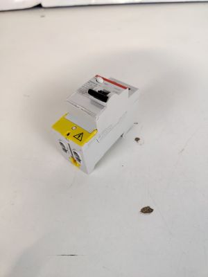 une boîte blanche sur laquelle est collé un autocollant jaune, posée sur une table