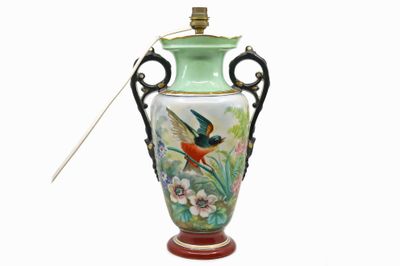 un vase vert orné d'un oiseau et contenant une cuillère