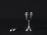 silver goblet and spoon on a black background
